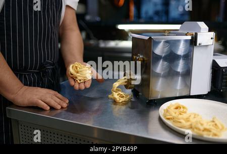 Closeup handmade egg pasta tagliatelle in chef hand Stock Photo