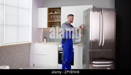 Male Worker Repairing Refrigerator With Screwdriver Stock Photo