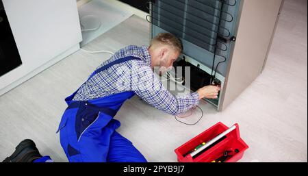 Testing Electric Appliance Using Multimeter To Repair Fridge Stock Photo