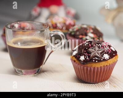 Cupcake with chocolate stars and coffee in front of gnome and snowman Stock Photo