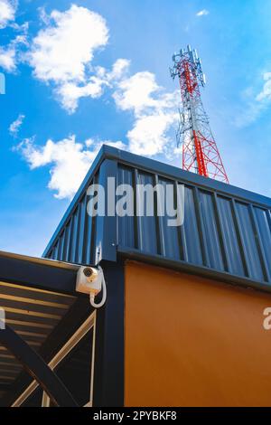 CCTV Camera and WIFI Device outside house for investigation and prevent criminal with communications tower in background. IP CCTV wifi surveillance ca Stock Photo