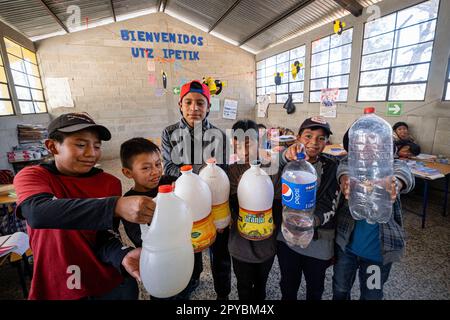 niños con garrafas de agua potable, escuela de primària, Patzojón Chiquito, Quiche, Guatemala, America Central Stock Photo
