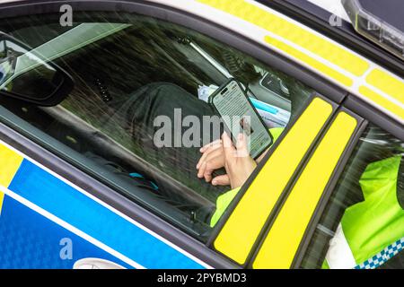 Greater Manchester.  3 May 2023; Police officer reading a message on phone re Police behaviour guidelines and disciplinary measures - A Greater Manchester Police officer has been sacked after admitting an animal cruelty offence. Police Sergeant Martin Dunn, who worked in GMP's Specialist Operations Branch, admitted gross misconduct at an independent disciplinary panel at GMP Force Headquarters on 2 May 2023 and was dismissed without notice. Public trust and confidence in the police is vital and GMP does not underestimate the importance of officers and staff demonstrating the highest standards. Stock Photo