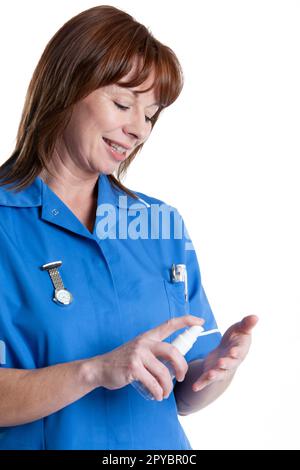 Health Professionals: Clean Hands. A uniformed medical nurse sterilising her hands. From a series of related images isolated on white. Stock Photo