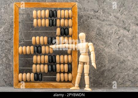 Wooden man counting with old wooden abacus Stock Photo