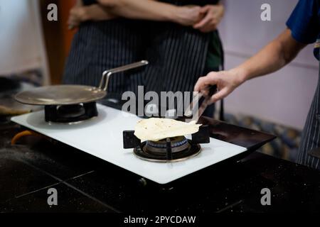 Traditional way of preparing indian food, making roti bread. Picture of traditional India cuisine made of fresh ingredients taken during cooking class Stock Photo