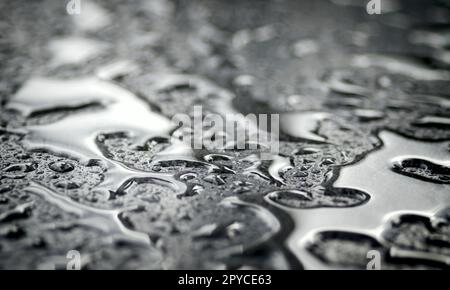 Close-up of waterdrops on silver surface. Horizontal image with selective focus. Stock Photo