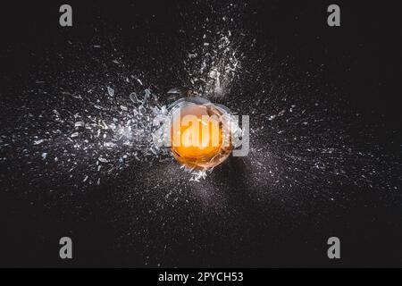 Explosion of glass ball and egg yolk Stock Photo