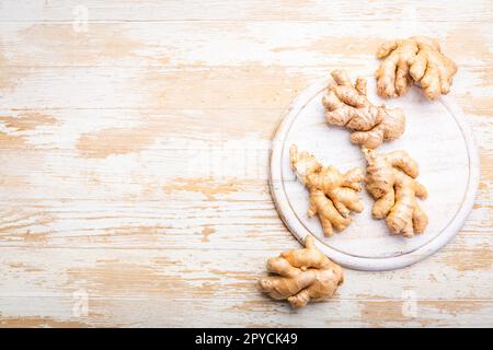 Fresh organic ginger roots on white wooden background. Stock Photo