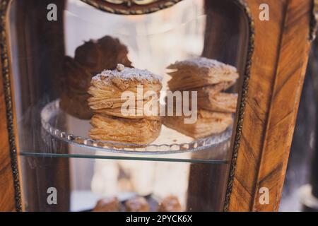 Puff pastry bun rolls sprinkled with sugar powder served in the cafe or bakery window. Homemade bakery product Stock Photo