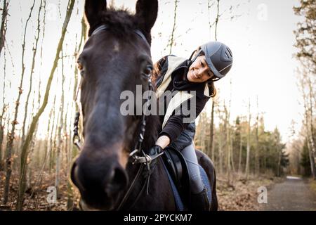 Female horse rider riding outdoors on her lovely horse Stock Photo