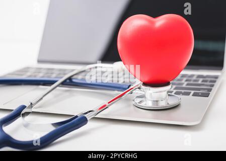 Health stethoscope and red heart on keyboard of laptop computer Stock Photo