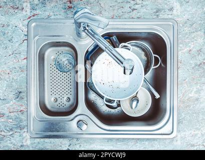 Dishwashing - pile of dirty dishes in kitchen sink Stock Photo