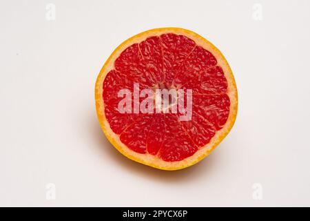 Sliced side of a grapefruit with red pulp isolated on a white background Stock Photo