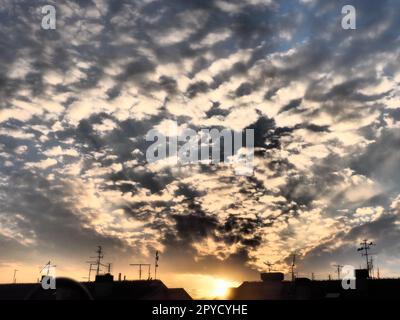 Black, gray and yellow sunset sky cloud. Dramatic sunset sky. Wonderful sunset. Clouds in the evening sky. The sun's rays pierce the clouds. Beautiful landscape. The sun goes down. Stock Photo