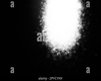 White bokeh and beam on a black background. Blurred glow from above on a dark surface. Night or space theme. Bokeh for the holiday. Association for a flying meteorite. Abstract theme Stock Photo