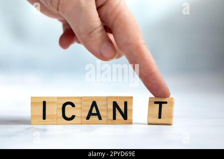 Change the word I can't to read I can concept for self belief, positive attitude and motivation, Hand removing the can't text wooden cubes background texture Stock Photo