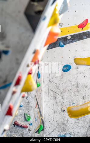 artificial climbing wall with grips and carabiners in the interior Stock Photo