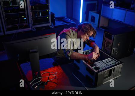 Man repairing computer system unit in modern service center Stock Photo