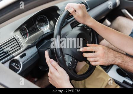 cropped view of father and son using steering wheel while driving car,stock image Stock Photo