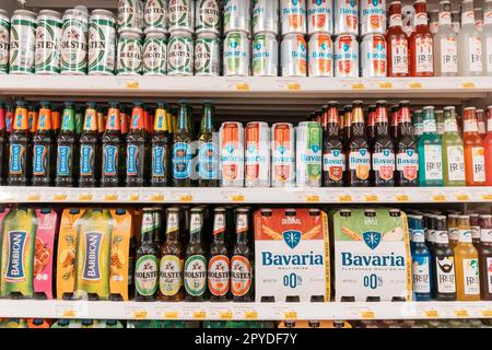 13 January 2023, UAE, Dubai: Assortment of Alcohol free beer bottles on a shelf of beverage shop Stock Photo