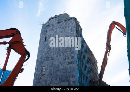Construction site digger yellow demolishing house for reconstruction Stock Photo