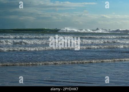 Many clouds en the blue sky and waves at the sea Stock Photo