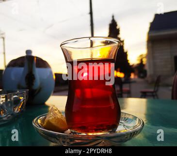 Turkish tea in a glass on a table in a cafe at sunset Stock Photo