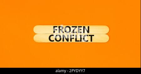 Frozen conflict symbol. Concept words Frozen conflict on beautiful wooden stick. Beautiful orange table orange background. Business and Frozen conflic Stock Photo