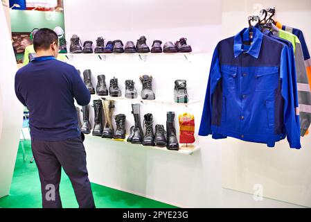Man on exhibition of shoes and clothing Stock Photo