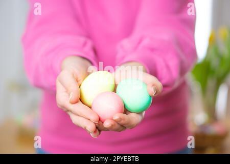 Close up of colorful homemade Easter eggs. Female hands holding colored Easter eggs. Stock Photo