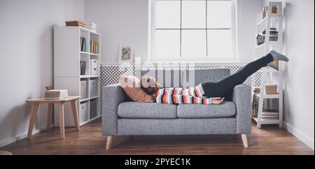 Tired woman lying on the sofa after hard day. Stock Photo