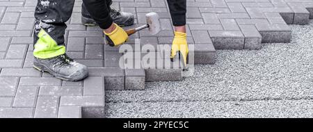 rubber hammer for adjusting the lock paving on the sidewalk. banner with copy space Stock Photo