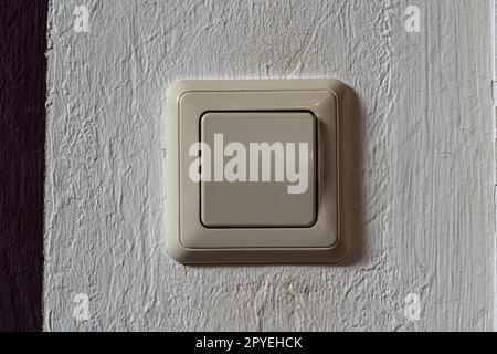 Light switch on the white wall to turn on the light Stock Photo
