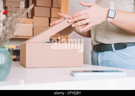 Cropped photo of woman hands packing, preparing parcel for delivery package to customers. Small business, online order Stock Photo