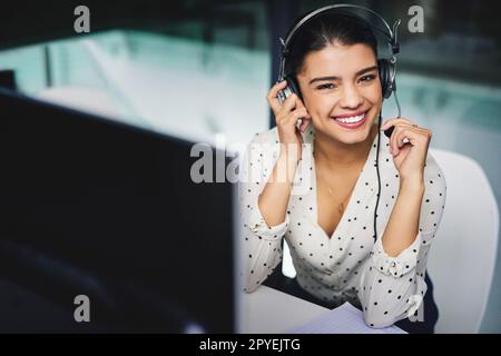 Im here to help. Cropped portrait of an attractive young businesswoman working late in a call center. Stock Photo