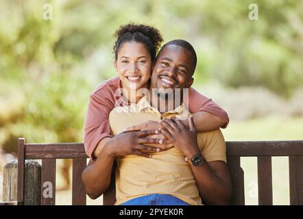 Love, portrait and couple hug in a garden, happy and smile while sitting, relax and bond in nature. Face, black family and man with woman in a park, quality time and enjoying peaceful day in Mexico Stock Photo