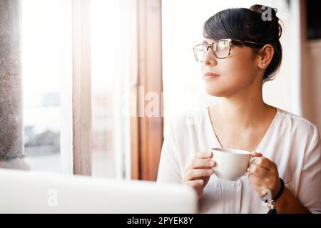 Its such a beautiful day outside. a beautiful young woman drinking coffee at a cafe while getting some work done. Stock Photo