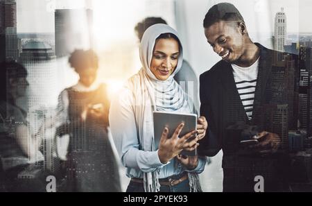 Just another busy day in the office. a group of young cheerful businesspeople browsing on digital devices while working together in the office at work. Stock Photo