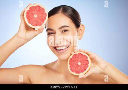 Beauty, health or woman with grapefruit for skincare wellness, facial cleaning or natural vitamin C in studio. Smile, cosmetics or happy girl model marketing fruit to detox for a glowing smooth face Stock Photo