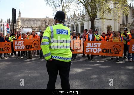 London, UK. 03rd May, 2023. A police officer speaks with protesters from Just Stop Oil as they slow march in Westminster, stopping the traffic outside Houses of Parliament. The group are demanding that UK government stops issuing new fossil fuel licences. Credit: SOPA Images Limited/Alamy Live News Stock Photo