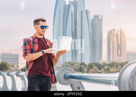 With the bustling energy of Abu Dhabi's downtown as his inspiration, a freelance worker focuses intently on his laptop, taking advantage of the UAE pr Stock Photo