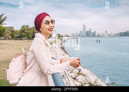 With the radiant sun shining down on her, an Indian girl proudly wears her turban as she takes a peaceful walk along the Abu Dhabi embankment, enjoyin Stock Photo