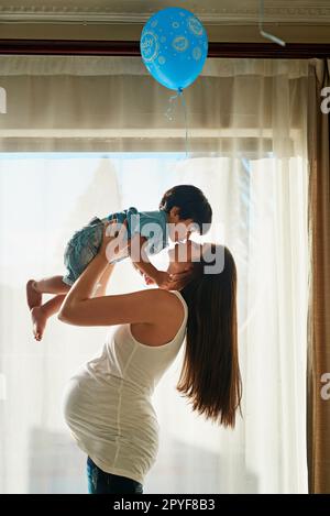 Youre going to be the best big brother. a pregnant woman playing with her little boy in her bedroom at home. Stock Photo