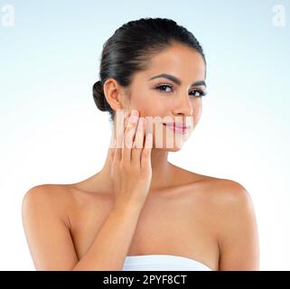 Respect your complexion by looking after it. Studio shot of a beautiful young woman posing against a blue background. Stock Photo