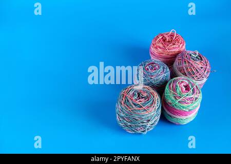 Various colored balls of yarn on a blue background. Space for text Stock Photo