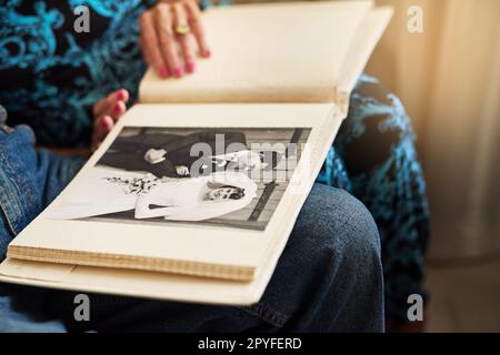 Remembering the day they said, I do. a senior couple looking through a photo album together at home. Stock Photo