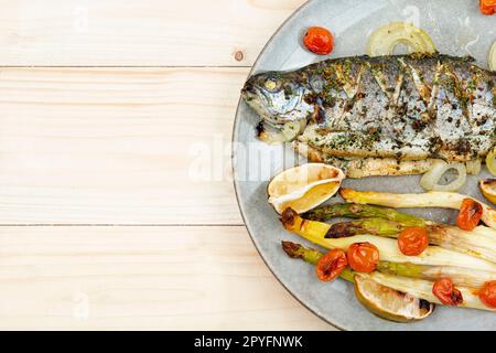 Trout baked with white asparagus, copy space Stock Photo