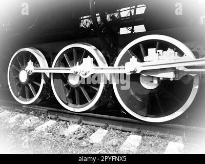 Retro train wheels. Beautiful card. Sleepers and rails, pistons and guides. Locomotive of the 19th early 20th century with steam engine. Vintage style. Black-white. White vignetting around the edges Stock Photo