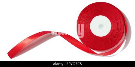 A spool with a red silk ribbon on a white isolated background, an object for decoration Stock Photo